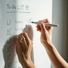 A person checking off tasks on a checklist